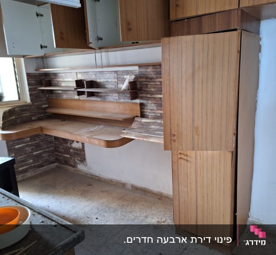 ארונות מטבח פתוחים עם מדפים ריקים וקערות על השיש